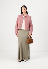 Rdeča in bela prugasta skrajšana jakna, bež top, olivno zelena krila in rjavek quilted torbica. Čevlji so svetli balerinki.
