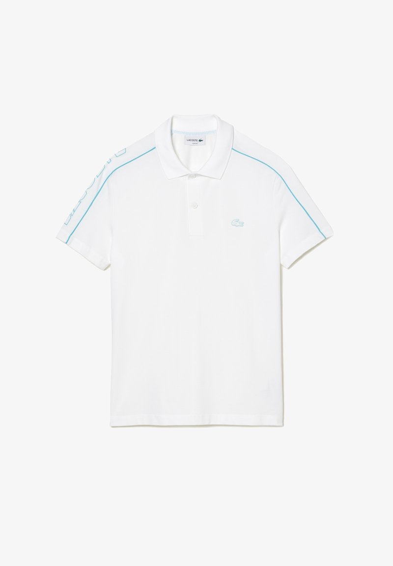Polo blanc en coton, avec un col, trois boutons et des accents bleu clair sur les épaules et sur le côté, avec un logo sur la poitrine.