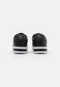 Black leather sneakers with a white sole and black accents. Gold logo on the heel. Rounded shape with padded collar for comfort.