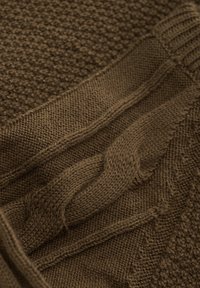 Brauner gestrickter Pullover mit strukturierten Mustern, Kabeldetails und gerippten Bündchen. Weiches Material in einem reichen, erdigen Farbton.