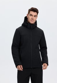 Veste softshell noire avec fermeture éclair à l'avant, capuche ajustable et deux poches latérales. Présente une texture lisse et un design minimaliste.