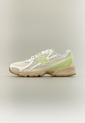 Baskets New Balance beige et vert clair avec texture en mesh, design à lacets et semelle en caoutchouc caramel, vues de profil sur un fond neutre.