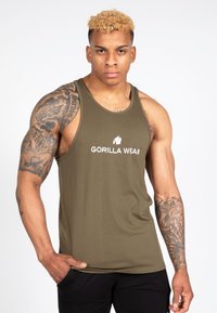 Olíva zöld ujjatlan felső, puha anyagból készült, fehér "GORILLA WEAR" logóval. Ujjatlan kialakítása kiemeli az izomformát.