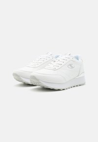 Witte sport sneakers met een glad leren bovenwerk, een gestructureerde rubberen zool, een gepolsterde kraag en platte veters. Voorzien van een subtiele logo aan de zijkant.