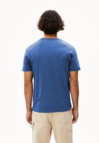 Blauw T-shirt met korte mouwen van katoen, met een ronde halslijn en een effen achterkant, gecombineerd met lichtbeige cargobroek.