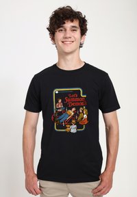 T-shirt en coton noir avec un graphisme coloré imprimé portant le texte "Let's Summon Demons" entouré de personnages de dessin animé autour d'un cercle.