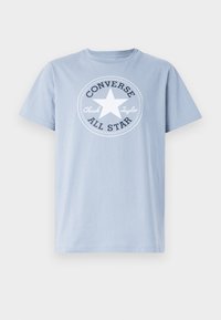 Tricou din bumbac de culoare bleu deschis, cu un grafic circular alb ce conține o stea și textul "Converse Chuck Taylor All Star" scris cu litere negre. Mâneci scurte.