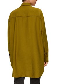 Oversized olijfgroene shirt van een zachte, gestructureerde stof, met knoopmanchetten en een afgeronde zoom, voorzien van een achterpand en een subtiele draping.