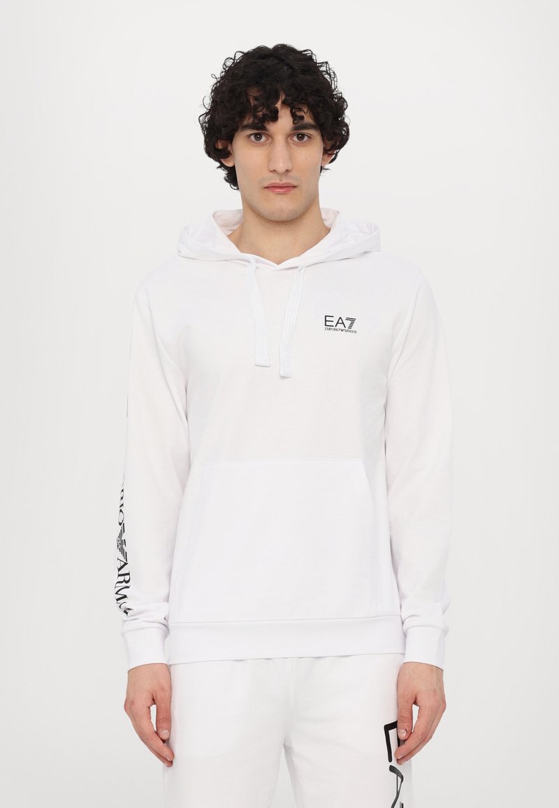 Hvid hoodie med snoretræk, kængurulomme og sort logo på brystet. Lange ærmer har sort tekstdesign. Blødt, glat stof.