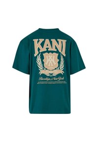 Tricou din bumbac de culoare teal, cu mânecă scurtă, având un text grafic mare bej "KANI" și un design cu un scut, împreună cu detaliul "Brooklyn, New York".