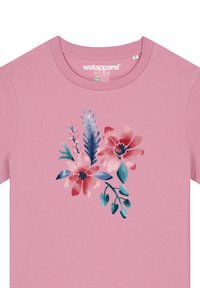 Roze katoenen T-shirt met een bloemenprint van rode en blauwe bloemen, groene bladeren en een aquarelstructuur. Ronde halslijn, korte mouwen.