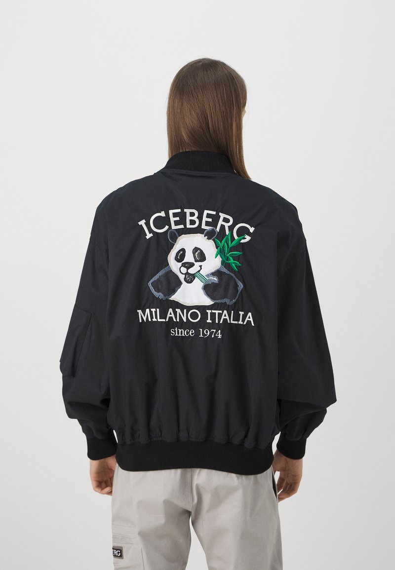 Giubbotto bomber nero con colletto e polsini a coste, caratterizzato da un design di panda ricamato e il testo "ICEBERG MILANO ITALIA dal 1974".
