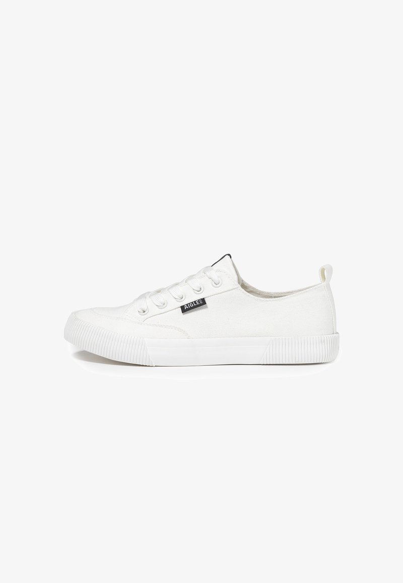 Sneaker en toile blanche avec un système de laçage, semelle en caoutchouc et une étiquette logo noire sur le côté. Présente un embout texturé et une languette au talon.
