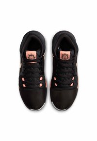 Black athletic shoes featuring a mesh upper, pink accents, black laces, and a textured sole. Notable logo on the tongue.