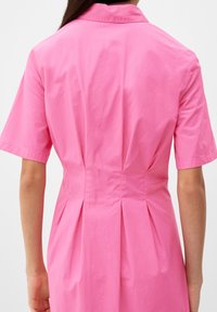 Różowa bawełniana sukienka z krótkimi rękawami, kołnierzykowym dekoltem i plisami z tyłu. Gładka tekstura i lekka konstrukcja z dopasowanym krojem.