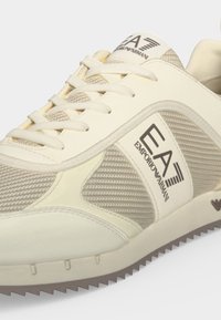 Κρεμ χρώματος αθλητικό παπούτσι EA Emporio Armani με ύφασμα από δίχτυ, κορδόνια και λογότυπο της μάρκας στο πλάι και στη γλώσσα.