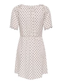 Robe rose clair à manches courtes avec des pois noirs, taille élastique, encolure froncée et bords de manches festonnés, vue de dos.