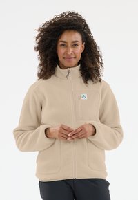 Beige fleecejacka med hög krage, hel dragkedja och en dragkedjeficka. Den har en texturerad yta och en liten logotyp på bröstet.