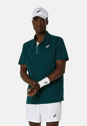 Türkisfarbendes Poloshirt mit weißem Kragen und Logo, kombiniert mit weißen Shorts. Accessoires umfassen eine weiße Kappe und ein Handgelenkband. Glatte Textur.