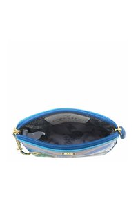Transparante cosmetica pouch met een blauwe rits, gouden hardware en een gestreepte binnenkant met zwarte illustraties op een lichte achtergrond.