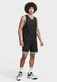 Melna basketbola krekls ar baltu apmali, komplektā ar atbilstošiem šortiem. Izgatavots no elpojoša materiāla, ar pieguļošu dizainu un Nike logotipu.