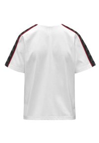 Camiseta blanca de algodón con mangas cortas, costuras de acento rojas y paneles negros con patrón y un logo en los hombros.