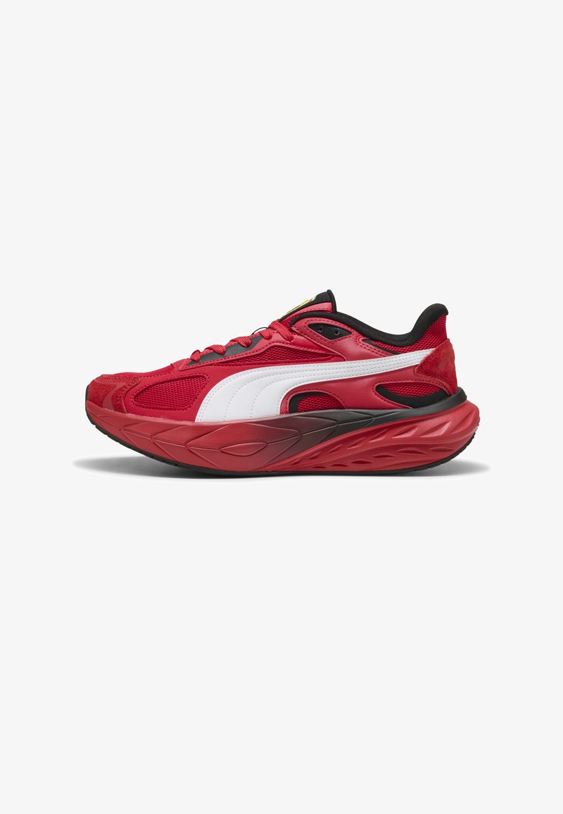 Baskets de sport rouges avec une semelle épaisse et texturée rouge, détail de bande blanche, accents noirs et empiècements en mesh, présentées de profil sur fond blanc.