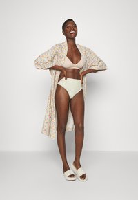 Kukkakuosiset kimono kevyestä kankaasta, beige rintaliivit, vaaleanvihreät alushousut ja valkoiset liukuvaimut. Lyhyet hihat ja löysä malli.