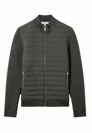 Chaqueta gris oscuro con cremallera, con una sección frontal acolchada y mangas sólidas. Presenta bolsillos laterales y puños y cuello acanalados.