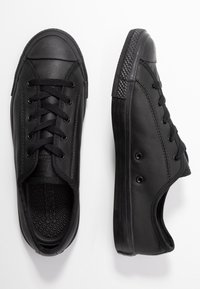 Paire de baskets basses en cuir noir avec semelles en caoutchouc et lacets noirs, présentées en vues de dessus et de côté sur fond blanc.