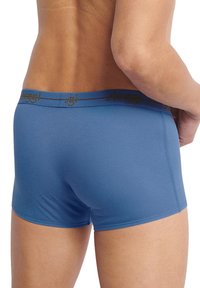 Boxer da uomo blu realizzati in tessuto morbido, con una cintura elastica con logo in testo dorato. Il design è aderente e senza cuciture.