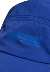 Niebieska czapka sportowa wykonana z lekkiego materiału, zdobiona haftowanym logo 'hummel PERFORMANCE'. Gładka tekstura z wzmocnionymi szwami.
