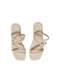 Sandali beige con molte cinghie sottili, punta quadrata e borchie a forma di piramide lungo i bordi. Realizzati in materiale gommoso liscio.
