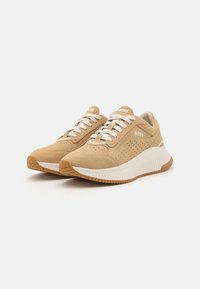Beige suedepumps med hvite detaljer, med perforerte sider, snøring og teksturert gummisåle. Merking på tunga og hælen.