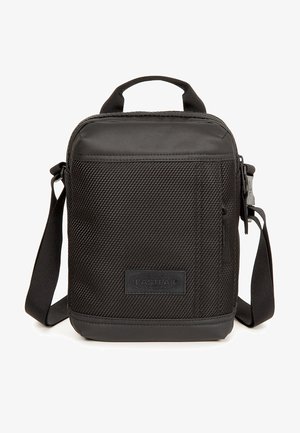 Black Eastpak bag with a textured exterior, zip closure, top handle, detachable shoulder strap, and a logo patch on the front.
