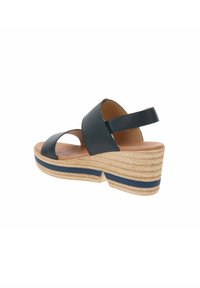 Sandali con zeppa in pelle blu scuro, dotati di ampie cinghie incrociate e una cinghia alla caviglia. Zeppa avvolta in juta con una striscia blu navy.