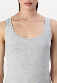 Grau Baumwolltanktop mit Rundhals, figurbetontem Design und glatter Textur. Keine Muster oder Verzierungen.