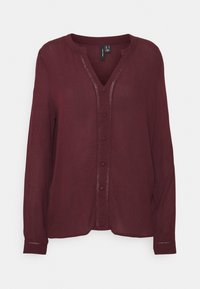 Bordeaux langærmet bluse med V-hals, knaplukning og dekorativ syning ned ad fronten. Fremstillet af et letvægts, tekstureret materiale.