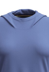 Light blue athletic top with a relaxed neckline, made from smooth, stretch fabric. Seam detailing visible near the shoulders.