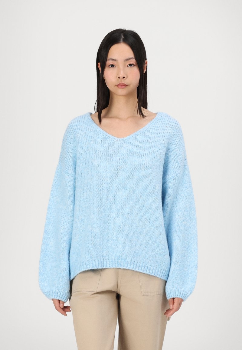 Lichtblauwe oversized trui met een V-hals, lange mouwen en geribde manchetten. Gemaakt van een gebreide stof met textuur, met een relaxte pasvorm.