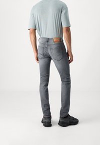 Slim-fit, grå denimjeans med en urtvättad finish, kontrasterande sömmar, två bakfickor och en märkesläderlapp på midjebandet.