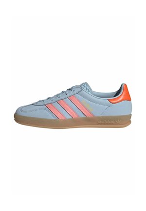 Lyseblå Adidas sneaker med lyserøde striber, orange hælkappe, gummisål og "GAZELLE" bogstaver på siden.