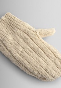 Mitaine tricotée de couleur crème avec une texture côtelée et un pouce séparé. Fabriquée avec un fil épais, elle présente une apparence douce et confortable.