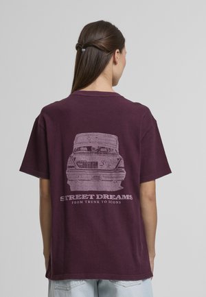 Bordové bavlnené tričko má na chrbte grafiku starožitného auta s textom „STREET DREAMS FROM TRUNK TO ICONS“ pod ním.