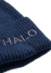 Granatowa dzianinowa czapka z prążkowaną fakturą i mankietem. Z przodu znajduje się jasno brązowe haftowane logo "HAL-O".