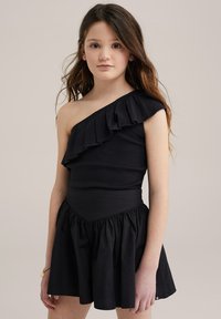 Svart enaxlad klänning med volangdetaljer, åtsittande bodice och utställd kjol. Tillverkad av mjukt tyg med en slät yta och elastisk midja.