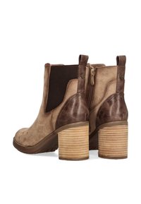 Botines de ante marrón con paneles elásticos laterales, una cremallera trasera y tacones apilados texturizados, que presentan acentos de cuero contrastantes.