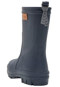 Botte en caoutchouc marine à la cheville avec une finition texturée, dotée d'une patch en cuir marron sur le côté et d'une languette avec un motif en chevron.