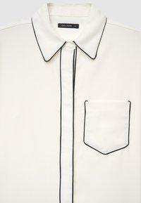 White shirt with black piping, featuring a classic collar, button front, and a small chest pocket. Smooth fabric and tailored design.