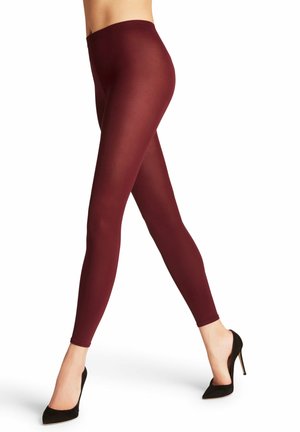 Leggings bordeaux realizzati in tessuto elastico e liscio, dotati di una vita alta e di un design aderente, abbinati a tacchi alti neri.